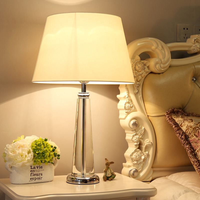 Lampada da tavolo conica in tessuto in stile rurale per camera da letto a testa singola luce notturna in beige con base di cristallo